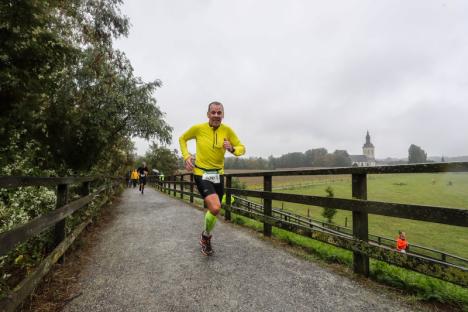 © Golazo Sports Een deelnemer loopt de brug naar de Hoegaardsestraat op in de gietende regen.