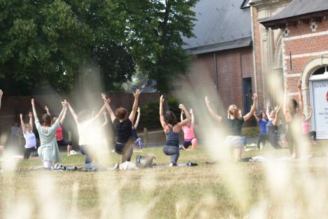 © Mula Yoga De yogasessie op het grasplein van het neerhof.
